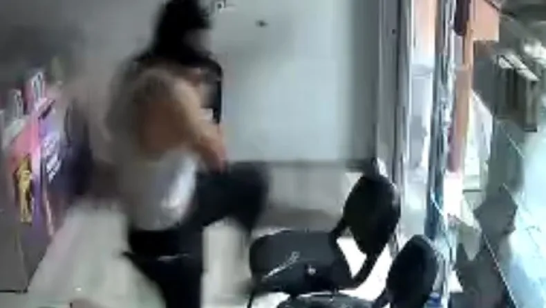 Beze sardığı kaldırım taşıyla telefoncu ve bankanın camını kırıp hırsızlık yapan şüpheli yakalandı; o anlar kamerada