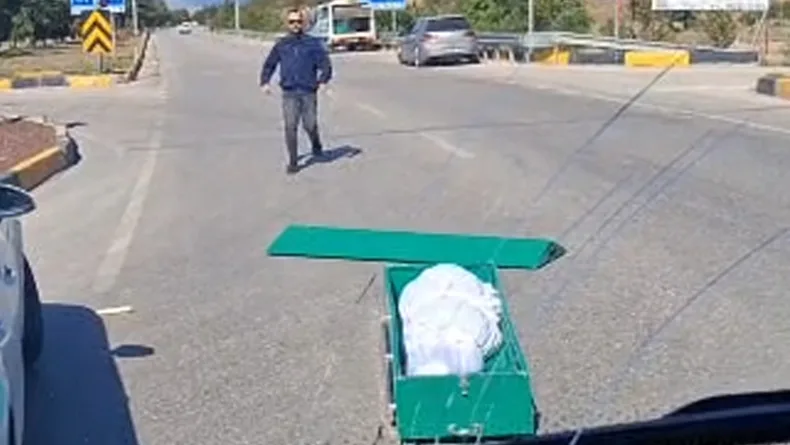 Seyir halindeki cenaze nakil aracından yola tabut düştü