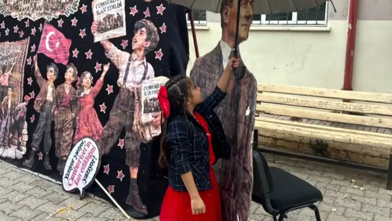 Yağmurda Atatürk maketini şemsiyeyle korudu